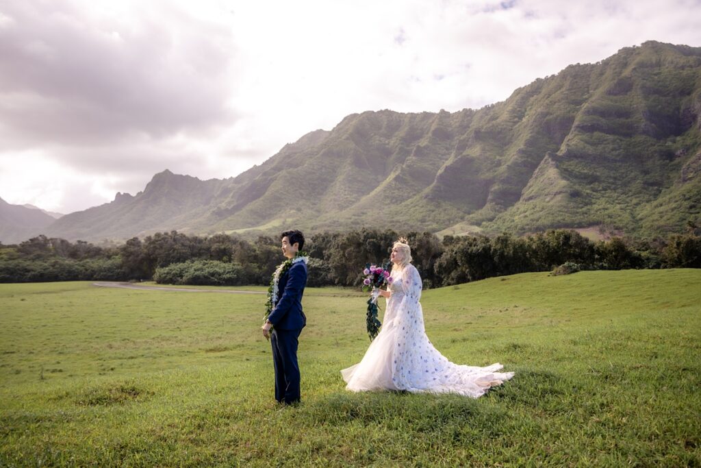bride and groom doing a first look with mountain backdrop, kualoa ranch wedding with Iwalani Photography