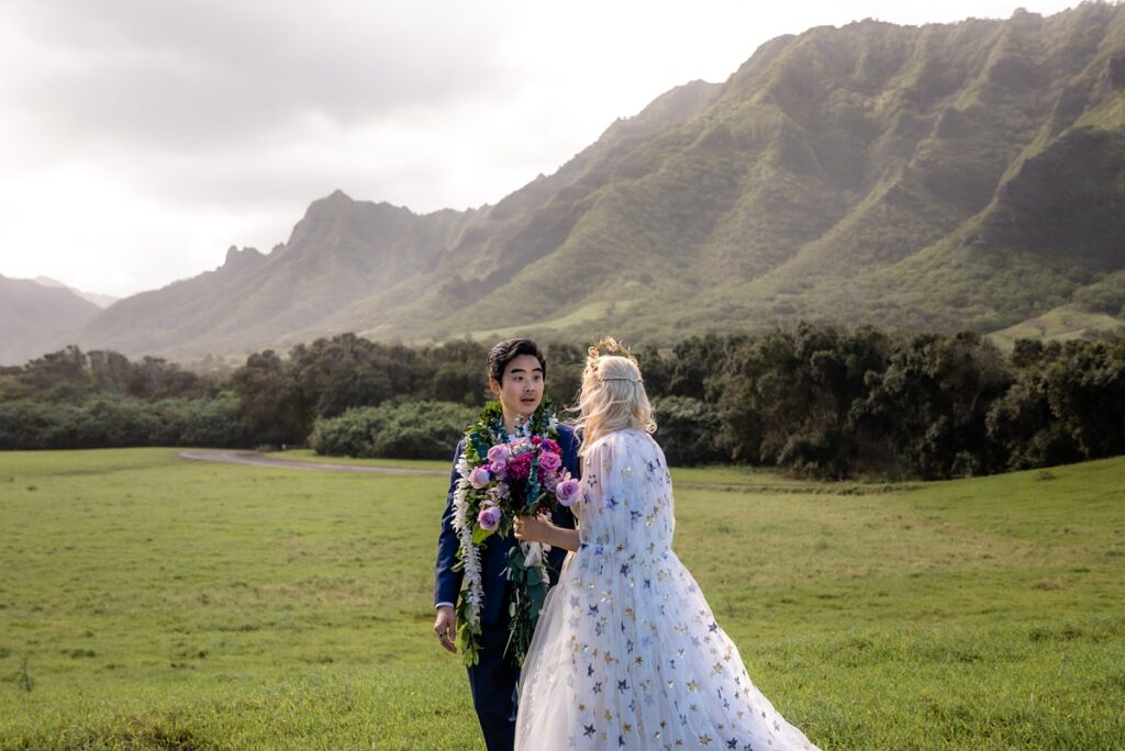bride and groom doing a first look with a mountain backdrop, kualoa ranch wedding with Iwalani Photography