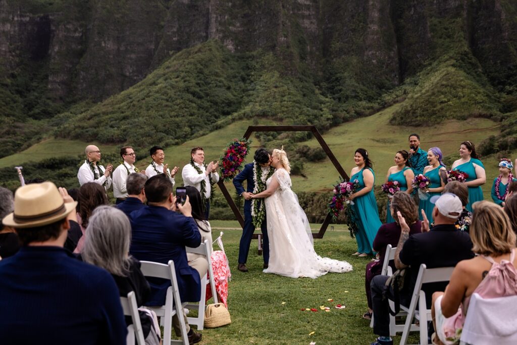 Groom kissing his bride at Kualoa Ranch Wedding Ceremony with Iwalani Photography