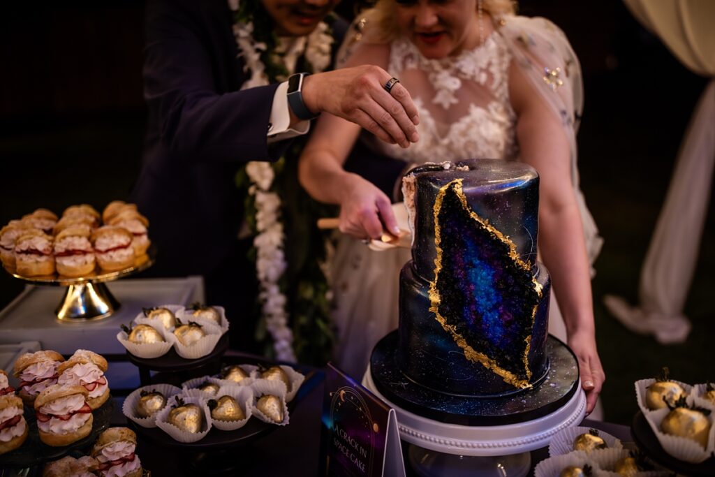 bride and groom cut their cake at Kualoa Ranch Wedding with Iwalani Photography